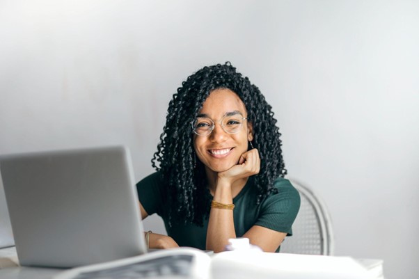 a happy woman at a computer who has focused on her digital wellness.