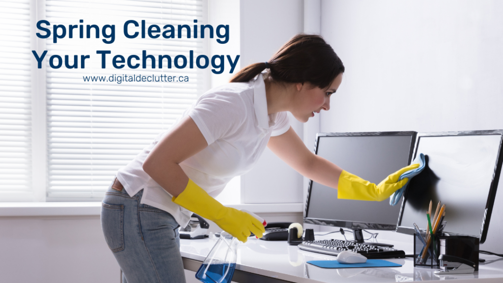 A woman wearing yellow gloves, holding a bottle of cleaning solution, and wiping her monitor as part of her spring cleaning routine.